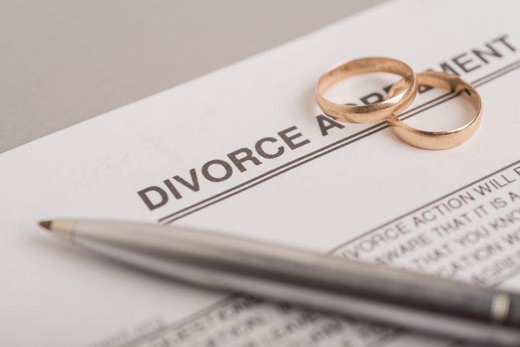 Two wedding rings placed on top of a divorce agreement, symbolizing the division of assets in a divorce. Understanding inheritance in Illinois divorce.