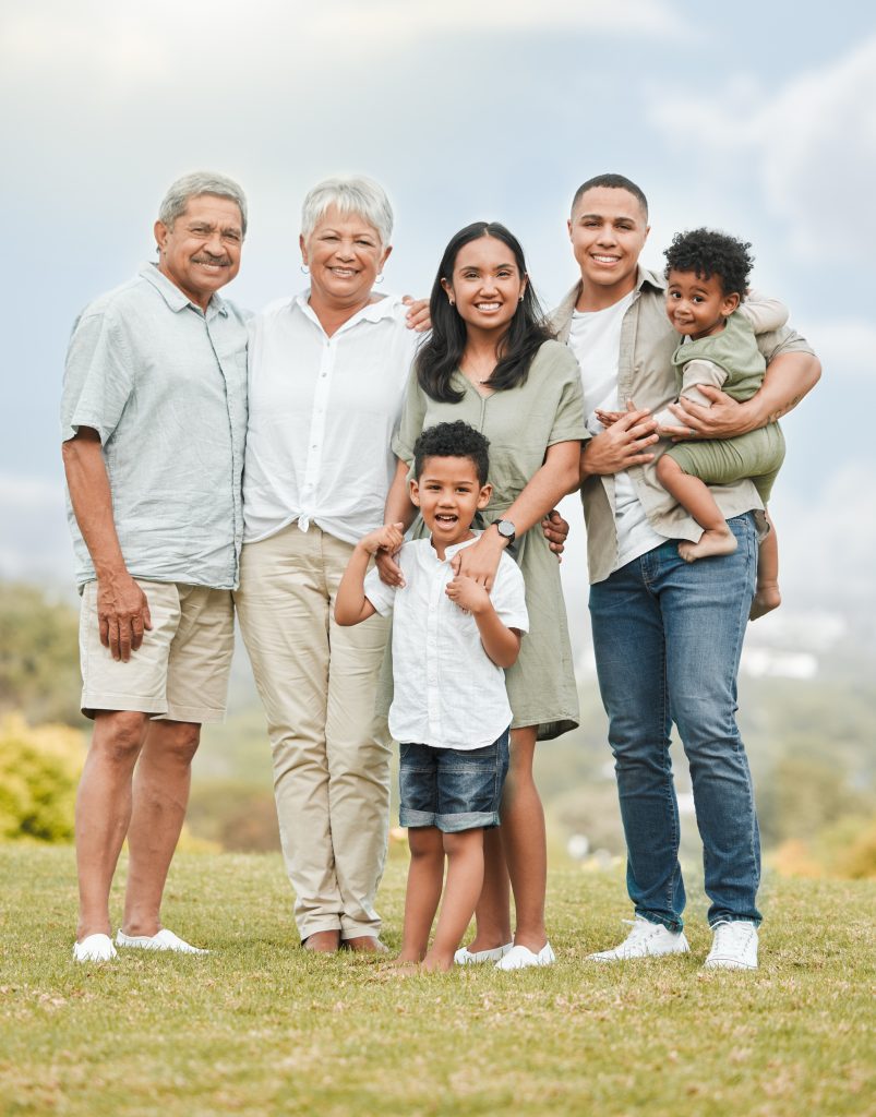 A happy multi-generational family standing outdoors, highlighting the importance of protecting family wealth and assets through probate in Illinois.